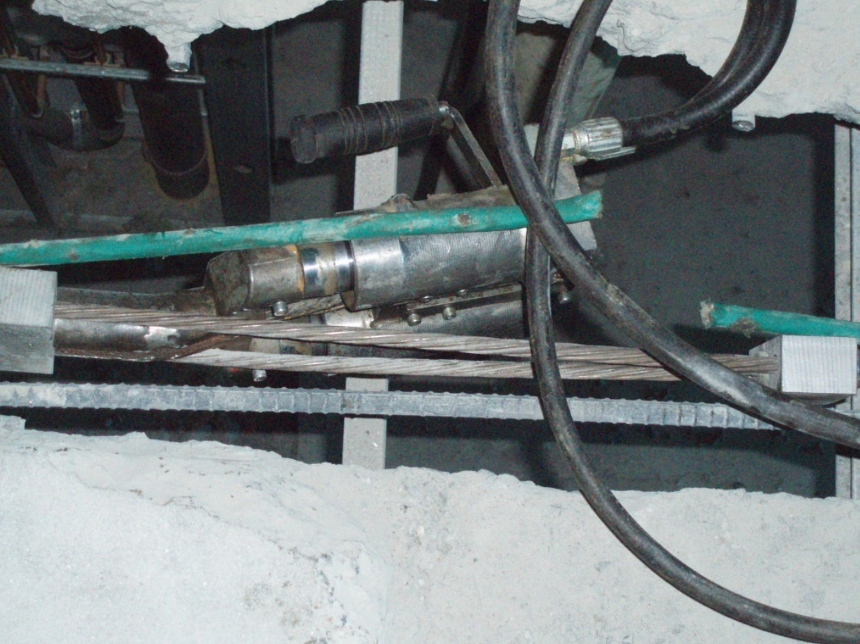 Technicians stressing post tension strands at a slab opening during post tension slab repair work